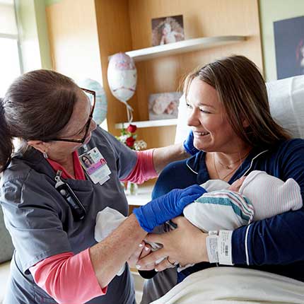 nurse with new parents and baby